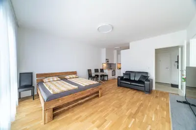 a bedroom with a bed and a living room at Apartment Michelská in Prague