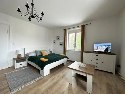 a bedroom with a bed and a tv and a table at Apartments Old Town in Brandýs nad Labem-Stará Boleslav