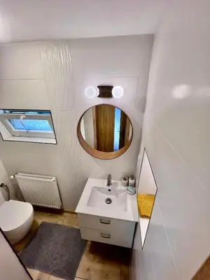a bathroom with a sink and a mirror and a toilet at Apartments Old Town in Brandýs nad Labem-Stará Boleslav