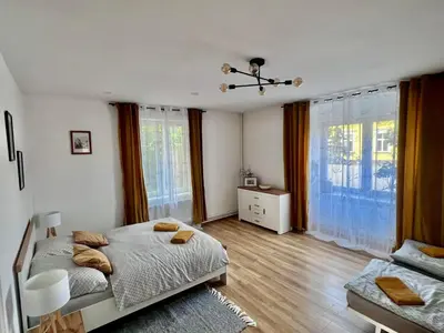 a bedroom with a bed and a large window at Apartments Old Town in Brandýs nad Labem-Stará Boleslav