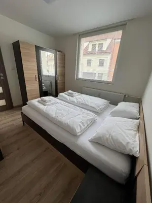 a bedroom with two beds and a window at Beroun apartments in Beroun