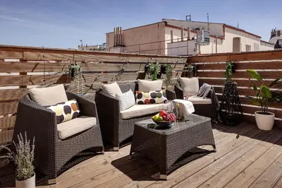 a patio with chairs and tables on a rooftop at U Pujcovny Apartment Old Town Prague in Prague