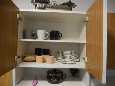 a cupboard filled with cups and saucers at Apartmán u zámku in Smečno