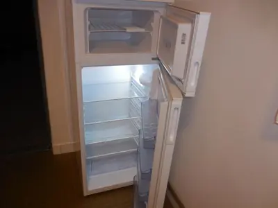 an empty refrigerator with its door open and a microwave at Apartmán u zámku in Smečno