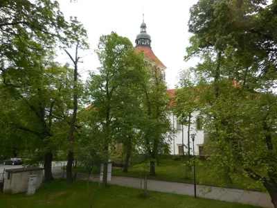 a large white building with a tower on top of it at Apartmán u zámku in Smečno