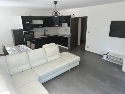 a living room with a white couch and a kitchen at Byt 71m2 klid pohoda a příroda in Prague