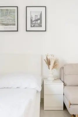a white living room with a couch and a chair at Cozy & New Studio Apartment PEACE SQ. in Prague