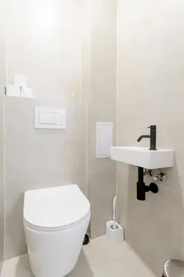 a white bathroom with a toilet and a sink at Cozy & New Studio Apartment PEACE SQ. in Prague