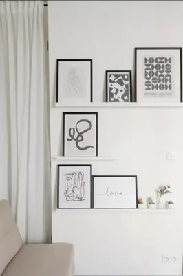 a living room with framed pictures on a wall at Cozy & New Studio Apartment PEACE SQ. in Prague