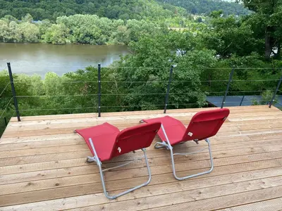 two red chairs sitting on top of a wooden deck at Apartmán - E - Vyhlídka nad řekou in Zdiby