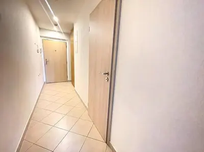 a hallway with a door and a tile floor at Garden Park Studio in Prague