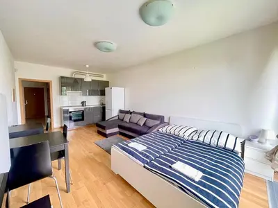 a bedroom with a bed and a living room at Garden Park Studio in Prague