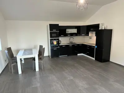 a kitchen with a white table and a white table and chairs at Apartmán byt 75m2 klid příroda pro rodinu in Prague