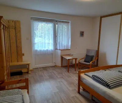 a bedroom with two beds and a desk and a window at Hrnčírna in Kněževes