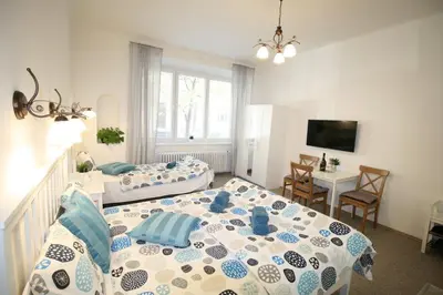 a bedroom with two beds and a table and a desk at Finnem Home Rentals in Prague