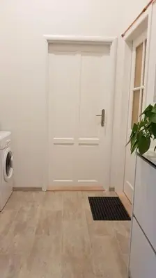 a white door in a room with a washing machine at Finnem Home Rentals in Prague