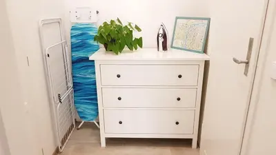 a white dresser with a plant on top of it at Finnem Home Rentals in Prague