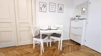 a white table with two chairs and a white refrigerator at Finnem Rentals Florenc in Prague