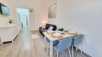 a living room with a white table and blue chairs at Finnem Rentals Florenc in Prague