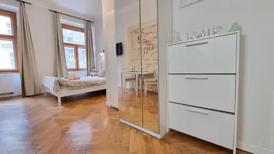a white dresser in a living room with a mirror at Finnem Rentals Florenc in Prague