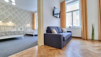 a living room with a chair and a bed at Finnem Rentals Tyršova in Prague