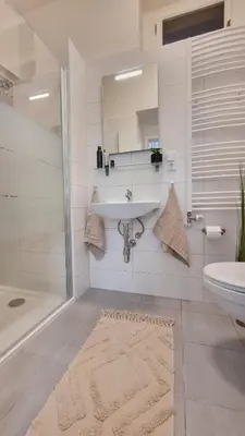 a white bathroom with a sink and a tub and a sink at Finnem Rentals Tyršova in Prague