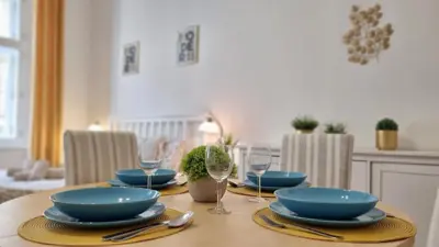 a dining room table with blue plates and glasses on it at Finnem Rentals Tyršova in Prague