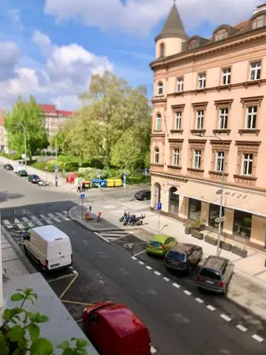 a city street with cars parked in front of a building at Karlin Cozy Studio in Prague