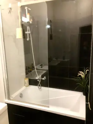 a bathroom with a shower and a white tub at Karlin Cozy Studio in Prague