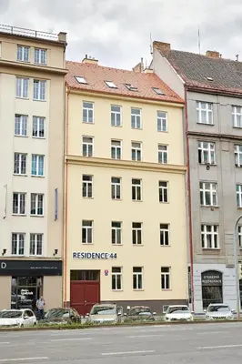a large yellow building with cars parked in front of it at Residence 44 in Prague