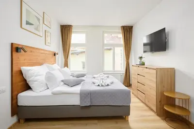 a bedroom with a bed with a television and a chair at Residence 44 in Prague