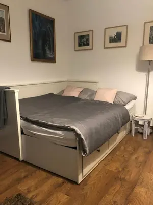a large bed in a bedroom with a wooden floor at Apartmán U jezírka in Velké Přílepy