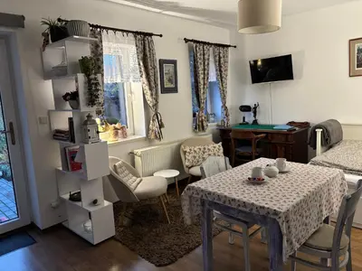 a living room with a table and a bedroom at Apartmán U jezírka in Velké Přílepy