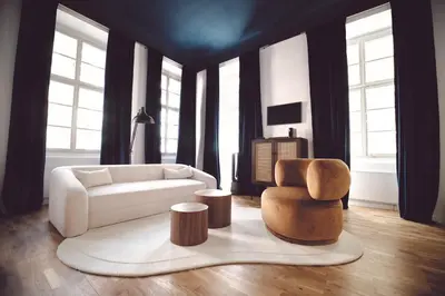 a living room with a white couch and a chair at Domus Balthasar Boutique Hotel in Prague