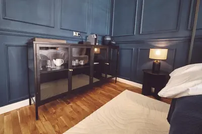 a bedroom with blue walls and a book shelf at Domus Balthasar Boutique Hotel in Prague