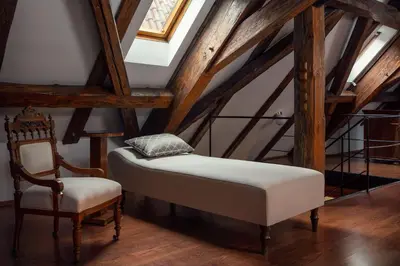 a bed and a chair in a attic at Prague Old Street Apartments in Prague