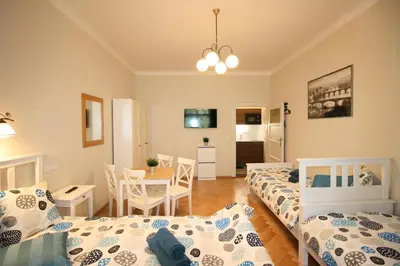 a bedroom with two beds and a dining room at Finnem Rentals Pod Znonařkou in Prague