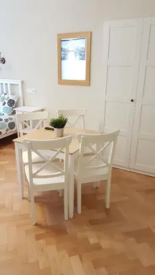 a white dining room with a table and chairs at Finnem Rentals Pod Znonařkou in Prague