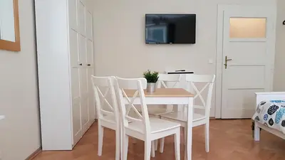 a white dining room with a table and chairs at Finnem Rentals Pod Znonařkou in Prague