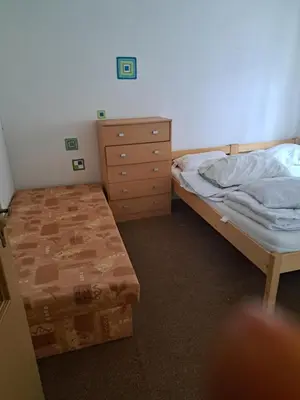a bedroom with two twin beds and a dresser at Domek u rybníka in Schloss Bösig