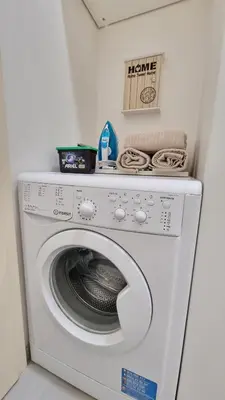 a white washing machine with a sign on top of it at Finnem Rentals Jičínská in Prague