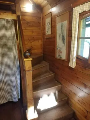 a staircase in a log cabin with a window at Chatrč pod Babou in Křivoklát