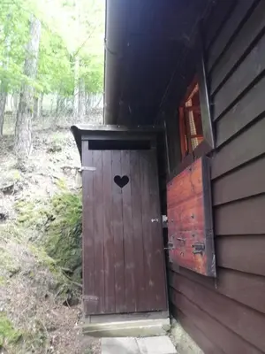 a door with a heart painted on the side of a cabin at Chatrč pod Babou in Křivoklát