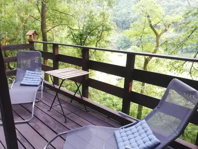 a balcony with chairs and a table and a view of a forest at Chatrč pod Babou in Křivoklát