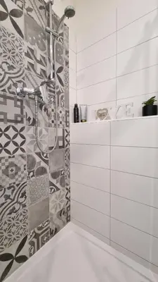 a bathroom with a shower and a tile wall at Finnem Rentals Zíkova in Prague