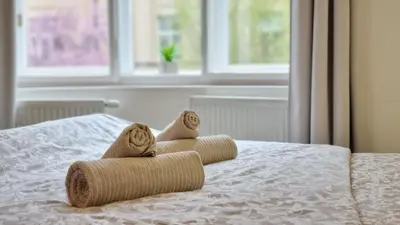 a bed with a pile of pillows on it at Finnem Rentals Zíkova in Prague