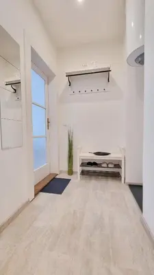 an empty white room with a table and a window at Finnem Rentals Zíkova in Prague