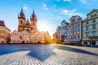 a city street with buildings and the sun setting at Finnem Rentals Sokolovská in Prague