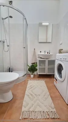 a bathroom with a shower sink and a washing machine at Finnem Rentals Sokolovská in Prague
