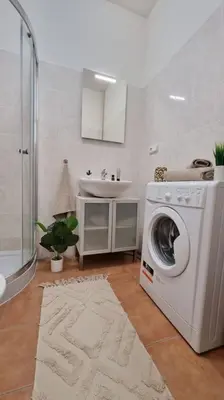 a bathroom with a washing machine and a sink at Finnem Rentals Sokolovská in Prague